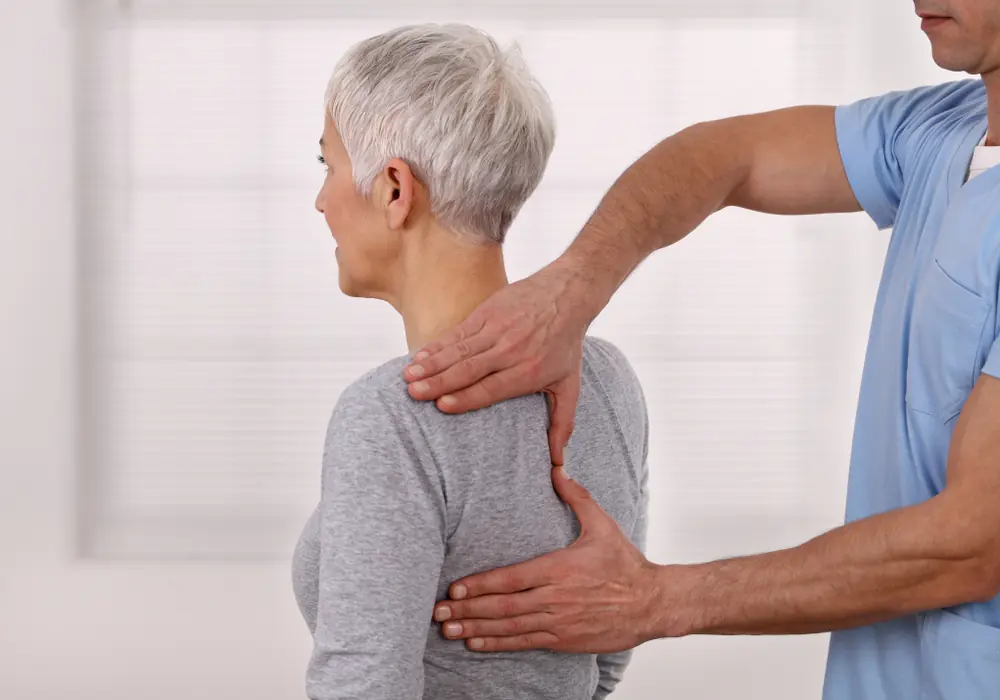 Chiropractor examining the upper back of a patient