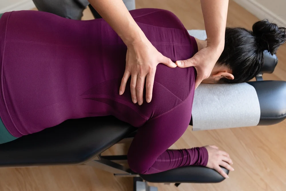 Woman having her back examined by a chiropractor